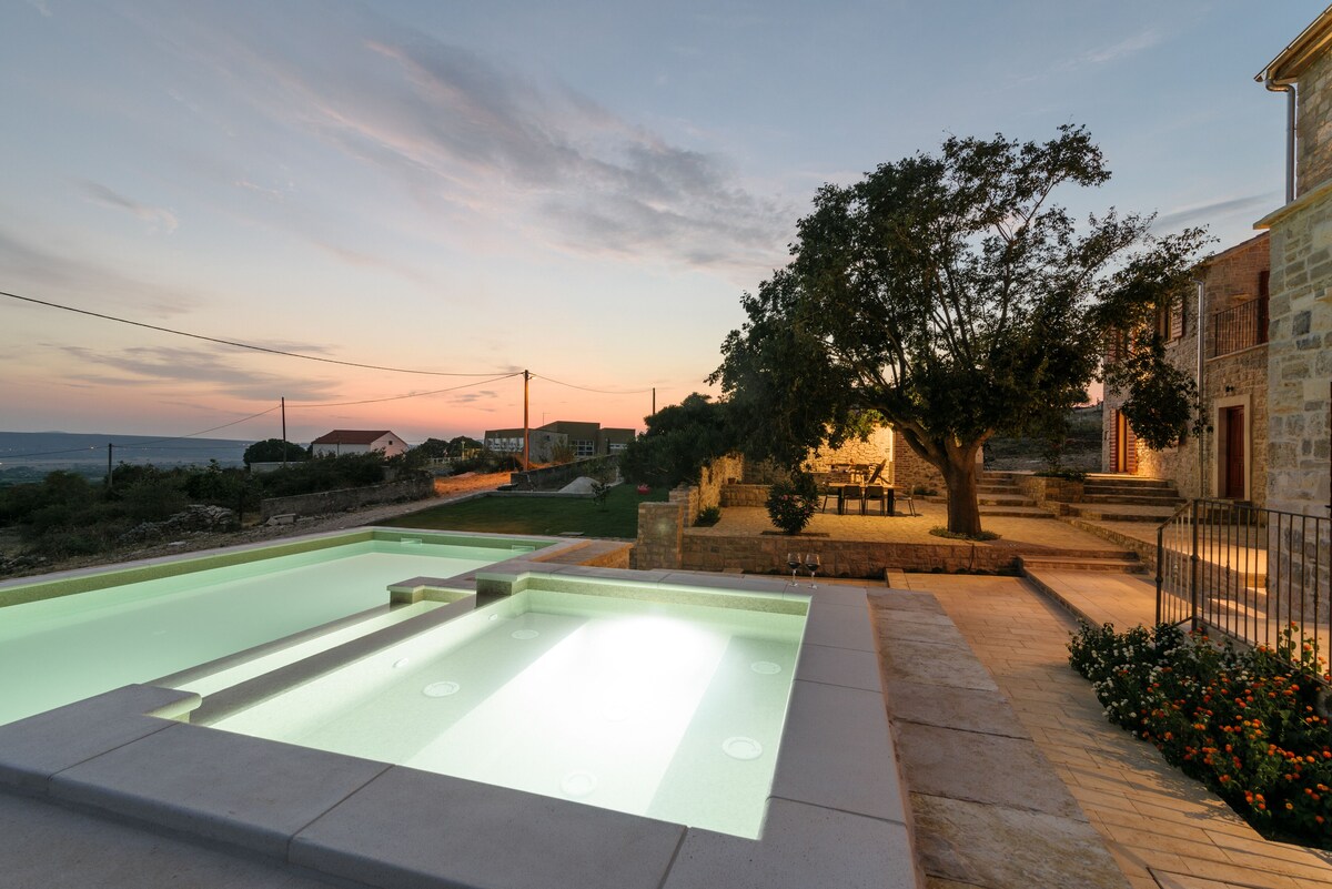 Heated pool and stone terrace at Authentic Stone Villa during the evening