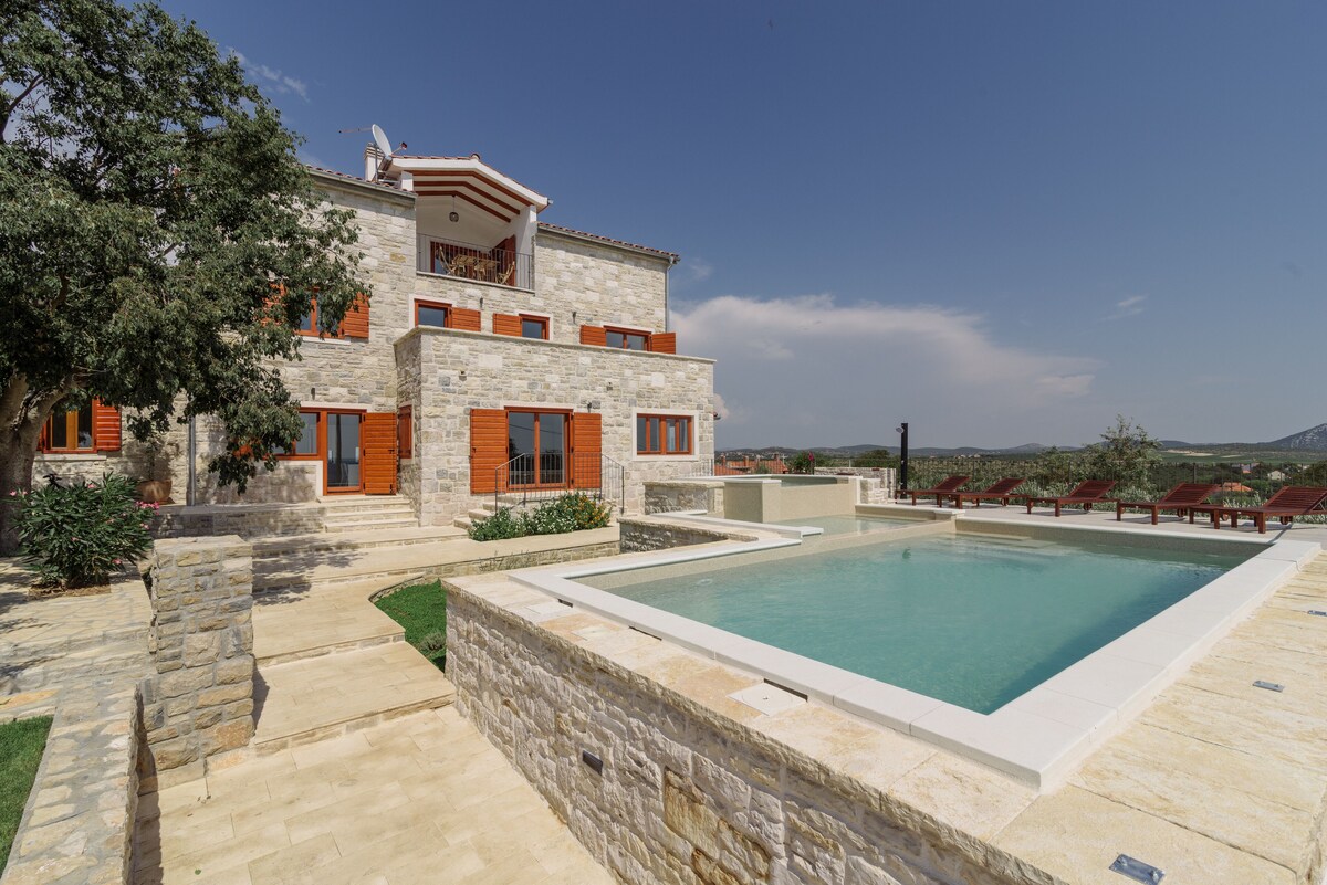 Daylight view of the pool terrace and façade of Authentic Stone Villa